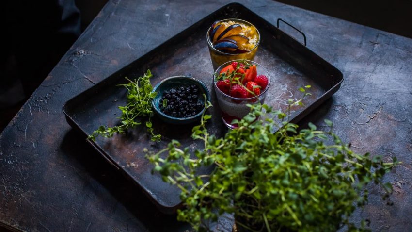 Fresh fruits with herbs on a rustic tray, perfect for healthy eating.